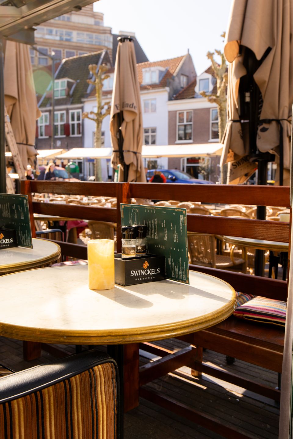 Gedekt tafeltje op het terras in de zon, met een kaarsje en uitzicht over de Botermarkt.
